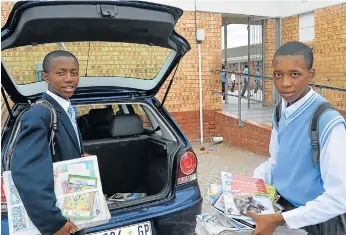  ?? Picture: LEBOGANG TLOU ?? READING MATTERS: Kuyasa Combined School Grade 11 pupils Masimbonge Viti, left, and Kuhle Pango lend a hand in offloading copies of Nal’iBali and other magazines donated to the school library