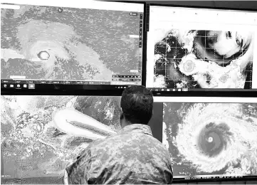  ??  ?? A member of the Emergency Operations Committee (COE) monitors the trajectory of Hurricane Irma in Santo Domingo, Dominican Republic. — Reuters photo