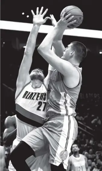  ??  ?? Nuggets forward Nikola Jokic drives to the basket on Trail Blazers center and former Denver teammate Jusuf Nurkic on Tuesday night in Portland, Ore. Steve Dykes, The Associated Press