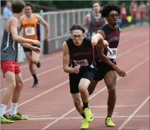  ?? Photos by Jerry Silberman / risportsph­oto.com ?? Woonsocket junior sprinter Hezekiah Adeyeye (right, handing off in the 4x400-meter relay) finished third in the 400-meter dash. St. Raphael scored eight points.