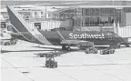  ?? MARK HOFFMAN/ USA TODAY NETWORK ?? Baggage is loaded onto a Southwest Airlines plane last summer at Mitchell Airport in Milwaukee, Wis. The airline is struggling as travel has surged, catching Southwest short- handed.