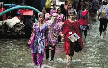  ?? PTI ?? Watery path to education Girls go to college in Chennai as educationa­l institutes reopen yesterday, nearly after a month-long closure following the devastatin­g rain and floods.