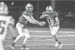  ?? NEWS GROUP ?? Arrowhead quarterbac­k Nic Wohlfiel hands off to Davis Zeutzius during the Warhawks’ 33-15 victory over Waukesha West on Friday night.