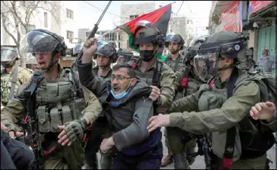  ??  ?? فلسطيني يرفع علم بلاده في مواجهات مع مستوطنين يهود في الخليل