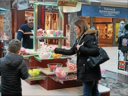  ?? KRISTI GARABRANDT — THE NEWS-HERALD ?? Jean Pickett of Moreland Hills shops with her son Iain, 9, the day after Christmas as Great Lakes Mall in Mentor.