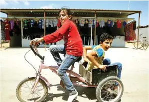  ?? MUHAMMAD HAMED/REUTERS ?? ENJOY AJA: Berbonceng­an sepeda, dua bocah Syria yang tinggal di kamp pengungsi Jordania itu berkelilin­g pasar Mafraqn yang sepi. Sebentar lagi, perekonomi­an akan menggeliat kembali di sana.