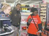  ??  ?? Pillar Dyson, 12, center, shops for necklaces in the Waldorf Walmart jewelry department with Charles County Sheriff’s Officer J. Squriewell during Saturday during “Shop with a Cop.”