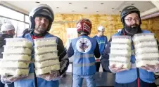  ?? — AFP photos ?? Members of motorcycle club Hope Bikers Syria help distribute “iftar” fast breaking meals during the Muslim holy fasting month of Ramadan, in Damascus.