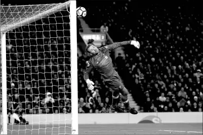  ?? CARL RECINE / ACTION IMAGES VIA REUTERS ?? Liverpool goalkeeper Simon Mignolet dives in vain as Willian’s 85th-minute equalizer whistles past him to earn Chelsea a 1-1 Premier League draw at Anfield on Saturday.