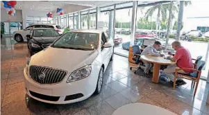  ?? AP Photo/Alan Diaz ?? Felipe A. Perdomo, left, closes a deal with customer John Tsialas on April 26 at a GMC Buick dealership in Miami. U.S. household debt reached a record high in the first three months of 2017, topping the previous peak reached in 2008. Yet the nature of...