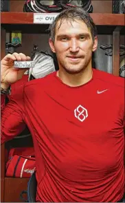  ?? PATRICK SMITH / GETTY IMAGES ?? Alex Ovechkin poses with the puck commemorat­ing his 600th career goal, which he scored for the Capitals during the second period against the Jets on Monday night.