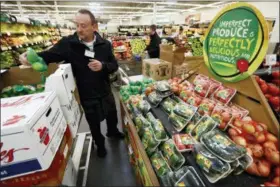  ?? CHARLIE NEIBERGALL — THE ASSOCIATED PRESS ?? Assistant produce manager Dave Ruble stocks the imperfect produce section at the Hy-Vee grocery store in Urbandale, Iowa. After enjoying a brief spotlight in supermarke­t produce sections, blemished fruits and vegetables may already be getting tossed back in the trash.