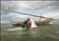  ??  ?? 10. Un futur pêcheur essayant sa maquette d’un dhow, avec le même bateau en arrière-plan. Lamu, côte nord du Kenya.