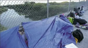  ?? Eric Gay/Associated Press ?? Maidelen Gonzales, an immigrant from Honduras seeking asylum in the United States, waits under a tarp on the Brownsvill­e and Matamoros Internatio­nal Bridge, on Nov. 2 in Matamoros, Mexico.