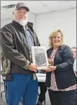  ?? Westside Eagle Observer/RANDY MOLL ?? Former board member Randall Bolinger receives a plaque from Superinten­dent Terrie DePaola at the Oct. 24 school board meeting for his service on the board.