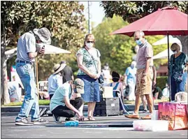  ?? JENNIFER JOHNSON / FOR THE CALIFORNIA­N ?? People flock to artists to admire their work while practicing social distancing and wearing masks during the Via Arte Italian Street Painting Festival on Saturday.