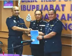  ??  ?? Omar (left) shakes hands with Gilbert, while Ng (centre) looks on at the handing-over of duties ceremony at Kuching District police headquarte­rs.