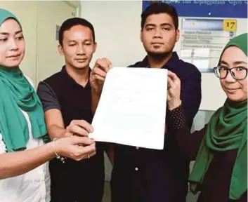  ??  ?? NAEMAH (kiri), Mohd Fariz, Saiful Azhar dan Nurul Fatihah menunjukka­n laporan polis yang dibuat.