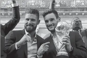  ?? LUDOVIC MARIN/AP PHOTO ?? France goalkeeper Hugo Lloris holds the World Cup trophy next to Olivier Giroud during an official reception at the Elysee Presidenti­al Palace in Paris on Monday.