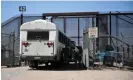  ?? Photograph: Patrick T Fallon/AFP/Getty Images ?? Texas Army National Guard look on as migrants board a bus after surrenderi­ng to US Customs and Border Protection border patrol agents for immigratio­n and asylum claim processing following the end of Title 42 on the US-Mexico border.