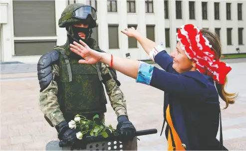  ?? SERGEI GRITS/ THE ASOCIATED PRESS ?? A woman embraces a soldier in an exaggerate­d show of friendline­ss in Minsk, the capital of Belarus, on Friday.