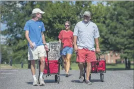  ?? VASHA HUNT — THE ASSOCIATED PRESS ?? Baylor Garland arrives to move in for his freshman year, assisted by his father Alan and mother Teena, at the University of Alabama on Saturday.