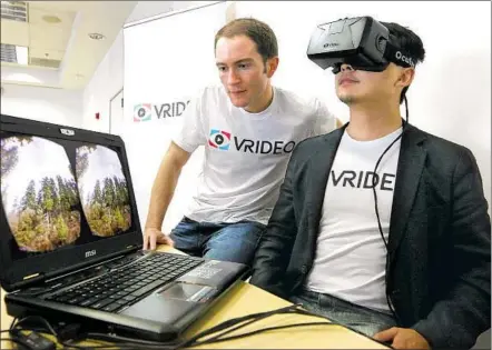  ?? Lawrence K. Ho Los Angeles Times ?? CO-FOUNDERS Alex Rosenfeld, left, and Kuangwei Hwang of Vrideo use an Oculus virtual reality viewer at a meet-up in Santa Monica in 2015. Vrideo, billed as the YouTube of VR, had to shut down in 2016 after discussion­s to sell the company fell through.