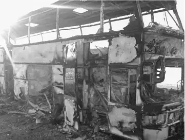  ??  ?? A charred bus on a road in the region around the city of Aktobe. — AFP photo