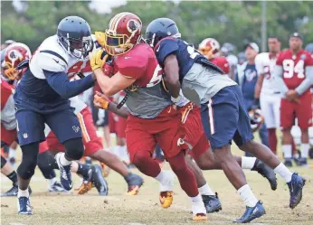  ?? AMBER SEARLS, USA TODAY SPORTS ?? Redskins linebacker Will Compton, center, participat­es in a drill Aug. 7 during a joint practice with the Texans. “It’s a great measuring stick for both sides,” Redskins coach Jay Gruden says.