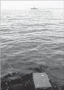  ?? DARREN PITTMAN/HALIFAX CHRONICLE HERALD FILE PHOTO ?? Half of a suitcase from the Swissair Flight 111 floats into shore at New Harbour, N.S. In the background is a Canadian Forces frigate.