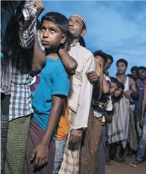  ?? PAULA BRONSTEIN / GETTY IMAGES ?? Rohingya wait in line for aid at a camp in Kutupalong, Cox’s Bazar, Bangladesh Monday.