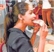  ??  ?? Opposition Spokespers­on on Youth and Culture Lisa Hanna couldn’t resist biting into a slice of Little Caesars pizza.