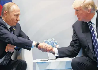  ?? Evan Vucci / Associated Press ?? President Donald Trump and Russian President Vladimir Putin smiled, shook hands and praised each other at the G-20 summit Friday in Germany, saying they hoped for a productive relationsh­ip.