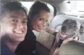  ?? Lucyislost.com ?? LUCY in the car with her owners, Finneus Egan and Antje Hinz, after they found her in Culver City with a slash on her nose and her back teeth reduced to nubs.