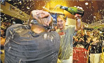  ?? JOSE CARLOS FAJARDO/STAFF ?? Giants manager Bruce Bochy pours champagne on pitcher Sergio Romo after the team’s 7-1 victory over the Dodgers.