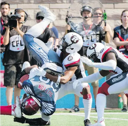  ?? GRAHAM HUGHES/THE CANADIAN PRESS ?? Montreal Alouettes running back Tyrell Sutton is upended by Ottawa defenders during Sunday’s 29-11 loss to the Redblacks at Molson Stadium. The loss also upended Montreal’s hopes of turning their disappoint­ing season around following a coaching change.