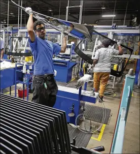  ?? TY GREENLEES / STAFF ?? Workers at Fuyao Glass America finish an automobile windshield in its Moraine plant. Unemployme­nt in the area is low, but wages have stagnated. Inflation-adjusted median household income is down 7 percent in Montgomery County since 2008.