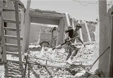  ?? AFP / Getty Images ?? Afghan Border Police personnel look through an outpost damaged in an airstrike Saturday in the Nad Ali district of Helmand province. An overnight U.S. air strike in southern Afghanista­n killed at least two policemen and wounded four others, officials...