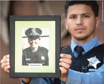 ??  ?? Officer Gino Garcia holds a portrait of his mother, Brenda Sexton, at CPD headquarte­rs last week. Garcia is a member of CPD’s Domestic Violence Unit, in part because Sexton, a Chicago police officer herself, was beaten to death by her boyfriend when Garcia was 6.
