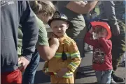  ?? ?? Orion Lewis, 5, of Vacaville has his turnouts straighten­ed during an open house at Vacaville Fire Station 73.