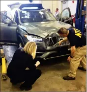  ?? NATIONAL TRANSPORTA­TION SAFETY BOARD VIA AP ?? IN THIS MARCH 20 PHOTO PROVIDED by the National Transporta­tion Safety Board, investigat­ors examine a driverless Uber SUV that fatally struck a woman in Tempe.