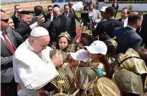  ?? EPA PIC ?? Pope Francis greeting children wearing pharaonic headdresse­s as he arrives to celebrate mass at the Air Defence Stadium in Cairo yesterday.