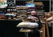  ?? (AP/Czarek Sokolowski) ?? A Ukrainian refugee carries pillows and blankets Thursday at a refugee center in Nadarzyn, near Warsaw, Poland.