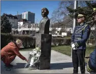 ?? (AP/Visar Kryeziu) ?? A woman lays a bouquet of flowers at the base of a statue of Madeleine Albright in Pristina, Kosovo, a day after the former U.S. secretary of state’s death.