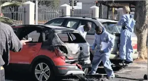  ??  ?? PAYBACK OR DIVERSION?: Ballistics investigat­ors comb the scene where a stolen VW Polo Cross was rigged with a device in an attempt to kill Radovan Krejcir in 2013.