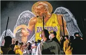  ?? AFP ?? Lakers fans in front of a mural of Kobe Bryant and his daughter Gianna Bryant on Sunday to celebrate after the Los Angeles Lakers defeated the Miami Heat in Game 6 of the NBA Finals.