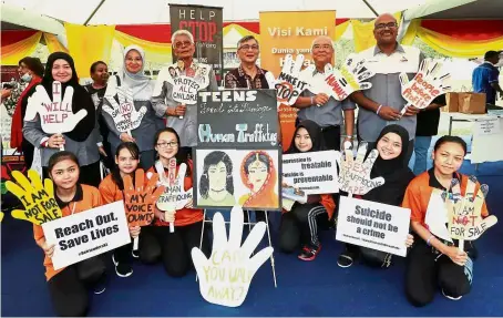  ??  ?? Supporting the cause: Razali (third from left) and Mohd Ariff (third from right) holding placards during the Human Rights Day celebratio­n at Padang Timur in Petaling Jaya.