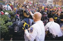  ?? VICTOR J. BLUE NYT ?? Supporters of President Donald Trump are detained by police officers during a clash with counterpro­testers in Washington, D.C., on Saturday.