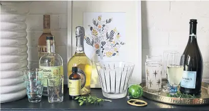  ?? DEBRA NORTON ?? Turn a sideboard into a bar or serving area stocked with glasses, an ice bucket and drink labels so guests can help themselves.