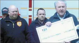  ?? PHOTO BY GIL COHEN — FOR DIGITAL FIRST MEDIA ?? State Sen. John Rafferty presents a $145,000 check from the state to Collegevil­le Fire Company No. 1 to help defray the cost of its new firehouse.